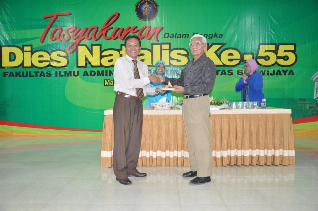 Dekan Prof Dr Bambang Supriyono menyerahkan nasi tumpeng kepada Drs Chalim Yusuf